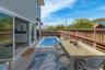 View of pool featuring a wooden deck, outdoor dining area, and a sink