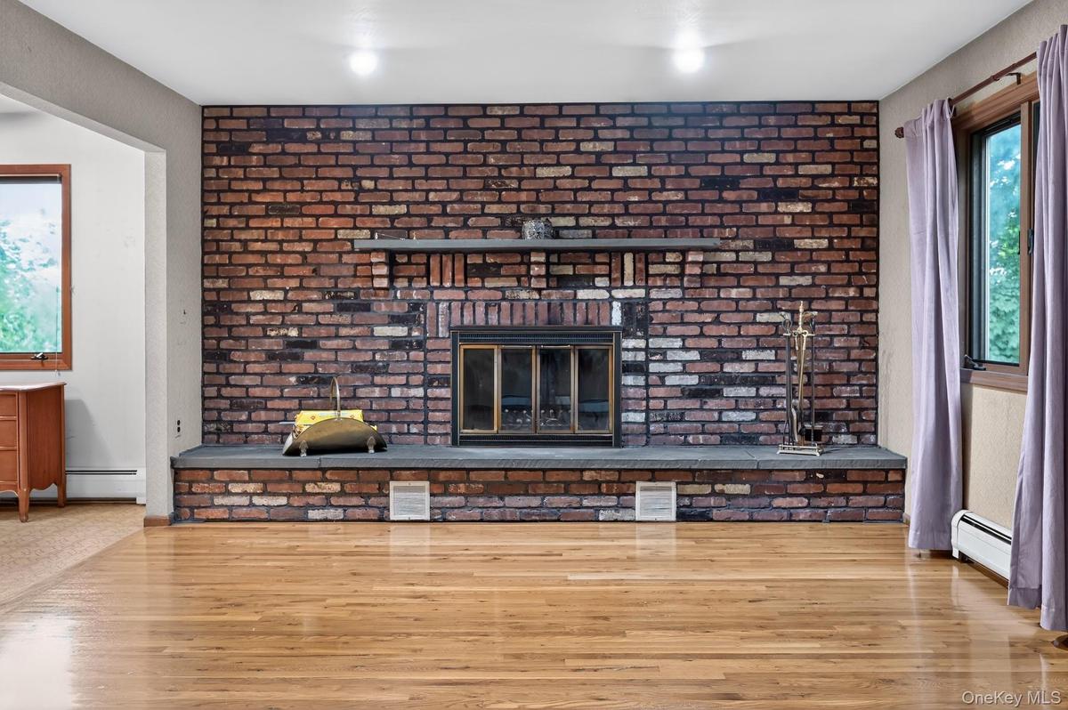 Brick-faced fireplace with a stone mantel and hearth