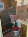 Bathroom with a stall shower, vanity, tile patterned floors, and tile walls