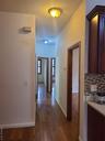 Hall with dark wood-type flooring and baseboards