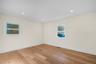 Room featuring warm-toned wood-finish flooring, light-colored walls, and recessed ceiling lighting