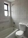 Full bathroom with shower / tub combination and tile walls