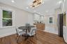 Open-concept dining area featuring wood-finish flooring, a contemporary chandelier, and recessed lighting