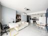 Living area featuring light marble finish floors, an AC wall unit, and an office area
