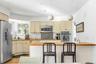Kitchen with wood counters, decorative light fixtures, sink, stainless steel appliances, and cream cabinets