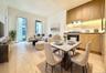 Open-concept living space featuring wood-finish flooring, a contemporary kitchen with wood cabinetry and stone backsplash, and floor-to-ceiling window