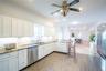 Kitchen with decorative backsplash, white cabinets, dishwasher, a peninsula, and a sink