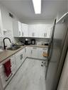 Kitchen with refrigerator, sink, and white cabinetry
