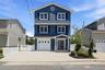 Three-story residence featuring blue siding with white trim and black shutters