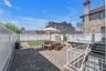 Backyard spacious wooden deck and brick patio , full sized shed at the corner