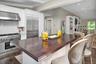 Kitchen featuring white cabinetry, premium appliances, under cabinet range hood, a kitchen bar, and recessed lighting