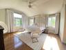 Bedroom featuring wood finished floors, vaulted ceiling, and a ceiling fan