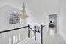 Hallway featuring an upstairs landing, light wood finished floors, vaulted ceiling, and a chandelier