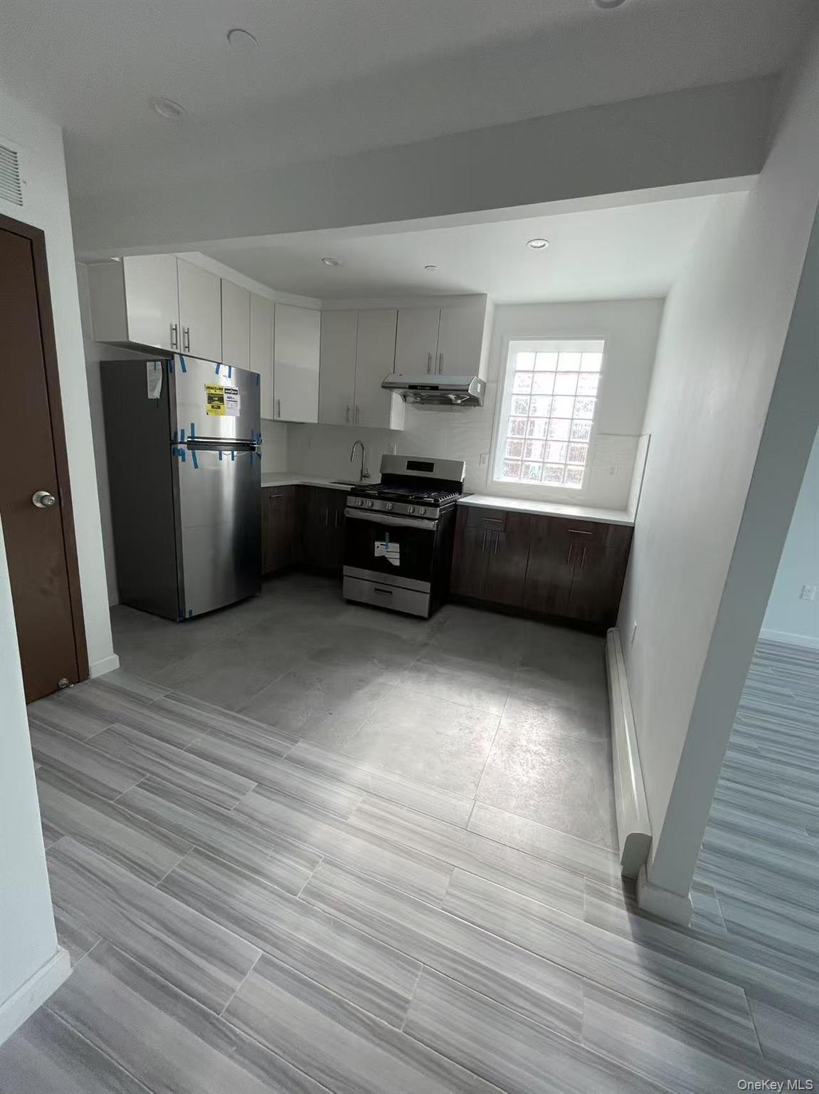 Kitchen with visible vents, stainless steel appliances, light countertops, under cabinet range hood, and a sink