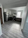 Kitchen with visible vents, stainless steel appliances, light countertops, under cabinet range hood, and a sink