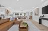 Open-concept living area with light wood-finish flooring, recessed lighting, and expansive windows