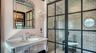 Glass-enclosed shower with marble tile