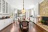 Dining space with crown molding, dark wood-style floors, a fireplace, and recessed lighting