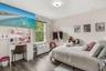 Bright secondary bedroom featuring abundant natural light, a spacious layout.