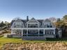 Rear view of property with a gambrel roof, french doors, a chimney, and a large porch