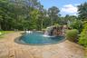 Swimming pool with a patio area and view of scattered trees