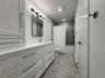 Bathroom with shower / bath combination with curtain, vanity, and baseboard heating