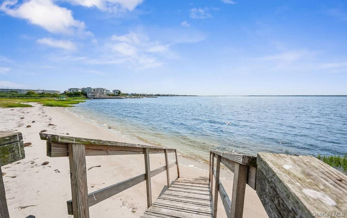 View of dock with a water view and a view of the beach