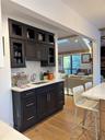 Kitchen featuring glass insert cabinets, light stone countertops, backsplash, open floor plan, and recessed lighting