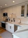 Kitchen with white cabinetry, sink, stainless steel appliances, and light hardwood / wood-style floors