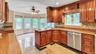 Kitchen featuring a wealth of natural light, granite finish floor, a ceiling fan, and dishwasher