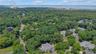 Aerial perspective showcasing a verdant, tree-lined residential area with multiple properties. Aerial Views of the proximity to the Long Island Sound