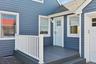 Doorway to property featuring roof with shingles and a deck