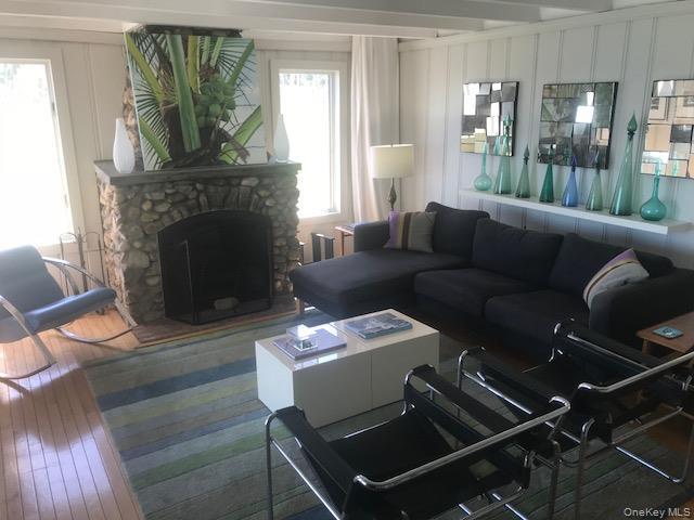 Living room with plenty of natural light, hardwood / wood-style floors, a decorative wall, and a fireplace