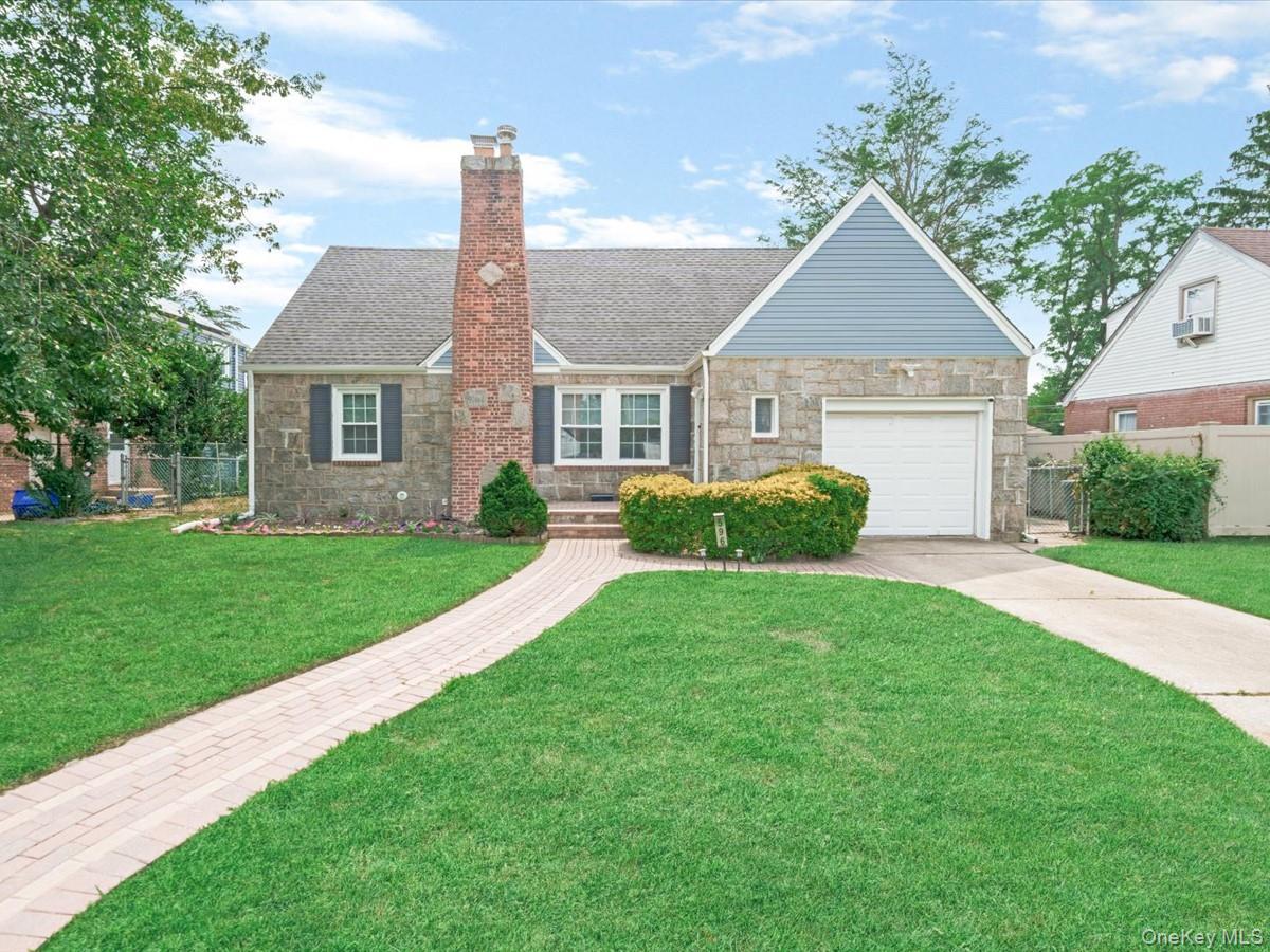 Stone and siding exterior with a prominent brick chimney, attached garage, and a paver walkway