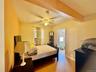 4 - Bedroom featuring a ceiling fan, beam ceiling, light wood-style floors, and baseboards