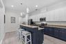 A Chef's dream kitchen with two-toned wood cabinets, prep island and breakfast bar for entertaining guests.
