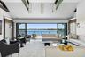 Living room with high vaulted ceiling, a water view, carpet floors, and recessed lighting