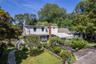 Extensive flowering gardens surround this unique property