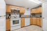 Well-maintained and inviting, this kitchen offers oak cabinetry, ample counter space, and a large, efficient cooking area.