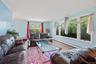 Living area with a baseboard radiator, crown molding, and wood finished floors