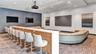 Bar-style seating in the screening room creates an inviting space for entertaining, celebrations, and enjoying sporting events with friends and neighb