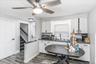 Modern kitchen area featuring white cabinetry, dark countertops, and wood-finish flooring