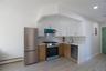 Kitchen featuring appliances with stainless steel finishes, backsplash, a baseboard heating unit, white cabinets, and light wood-type flooring