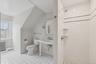 Bathroom featuring radiator, a stall shower, lofted ceiling, and light tile patterned floors
