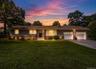 Siding exterior with stone veneer accents, multi-pane windows, covered entry, and attached two-car garage