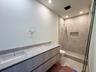 (as of April 8, 2026) a shared bathroom services both guest bedrooms on the second level with a double vanity and framess glass shower, also controlle