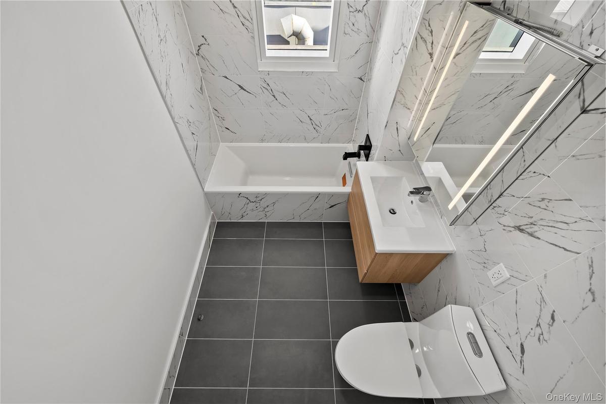 Bathroom with vanity and tile walls