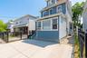 Light blue shingle and siding exterior with concrete driveway, black metal fencing, and a side walkway