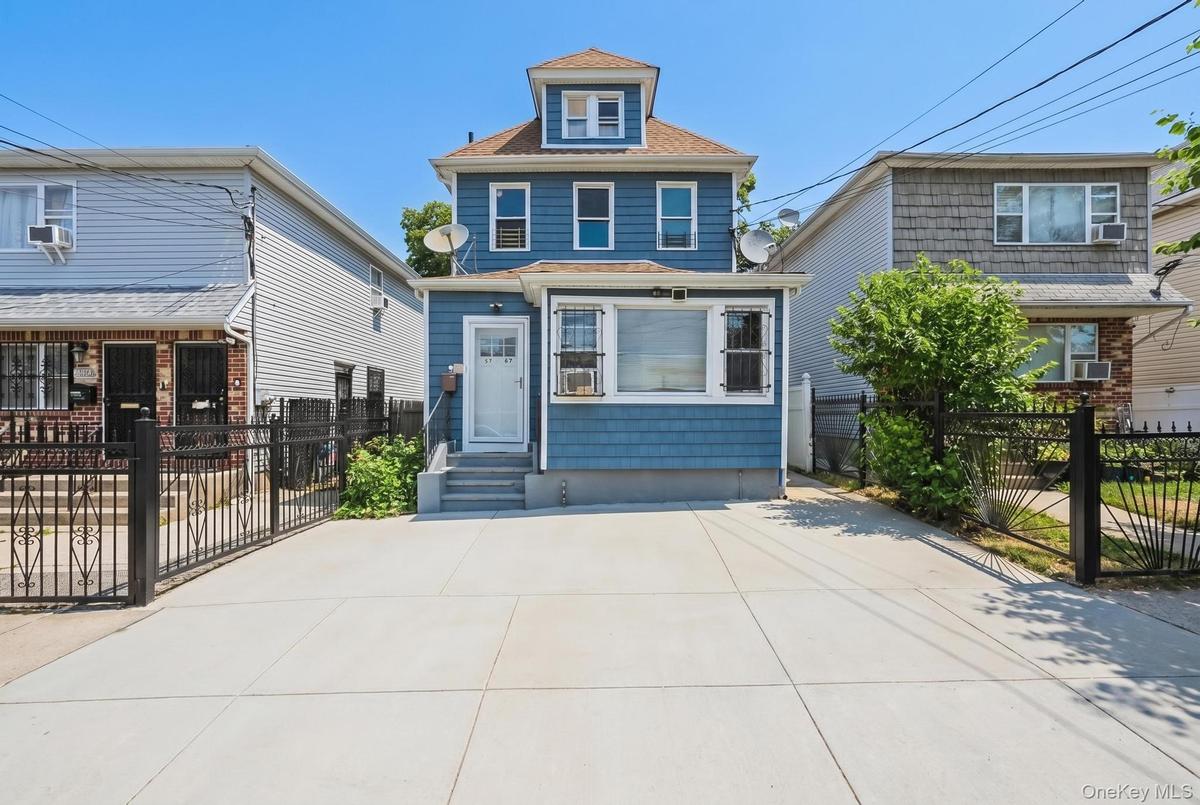 Three-story residence featuring blue siding and white window trim