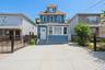 Three-story residence featuring blue siding and white window trim